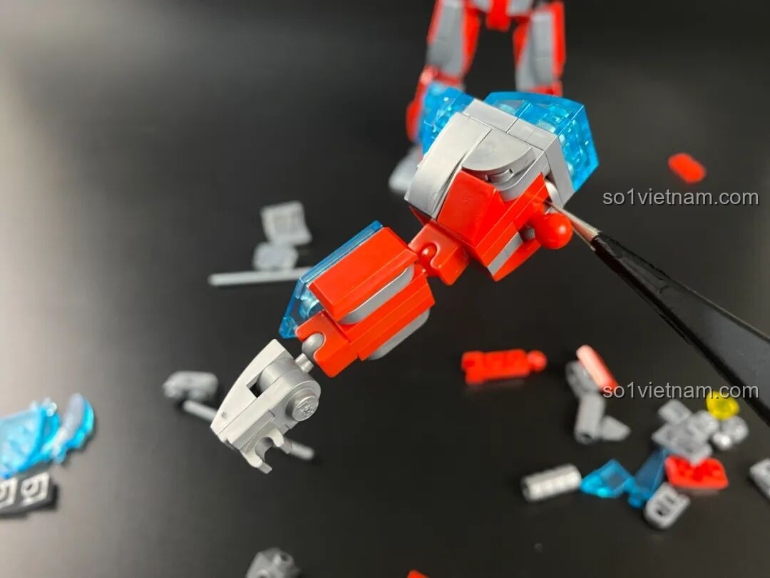 Quá trình lắp ráp phần vai của Mecha Ginga, sử dụng kẹp để gắn các chi tiết nhỏ.