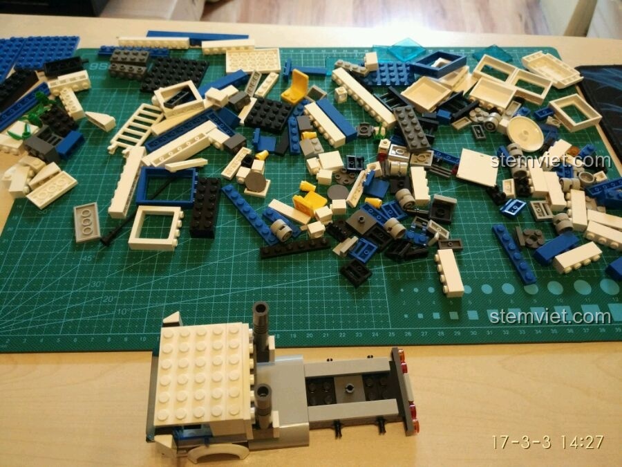 Các mảnh ghép của bộ đồ chơi lắp ráp GUDI 9316 được đổ ra thảm, sẵn sàng cho quá trình lắp ráp phần đầu xe tải cảnh sát.