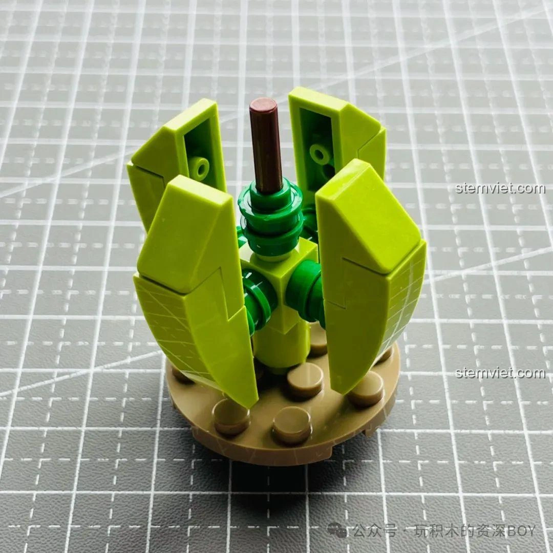 Mô hình cây xương rồng JAKI JK2727 đang trong quá trình lắp ráp, với bốn mảnh lá đầu tiên được gắn vào trục.