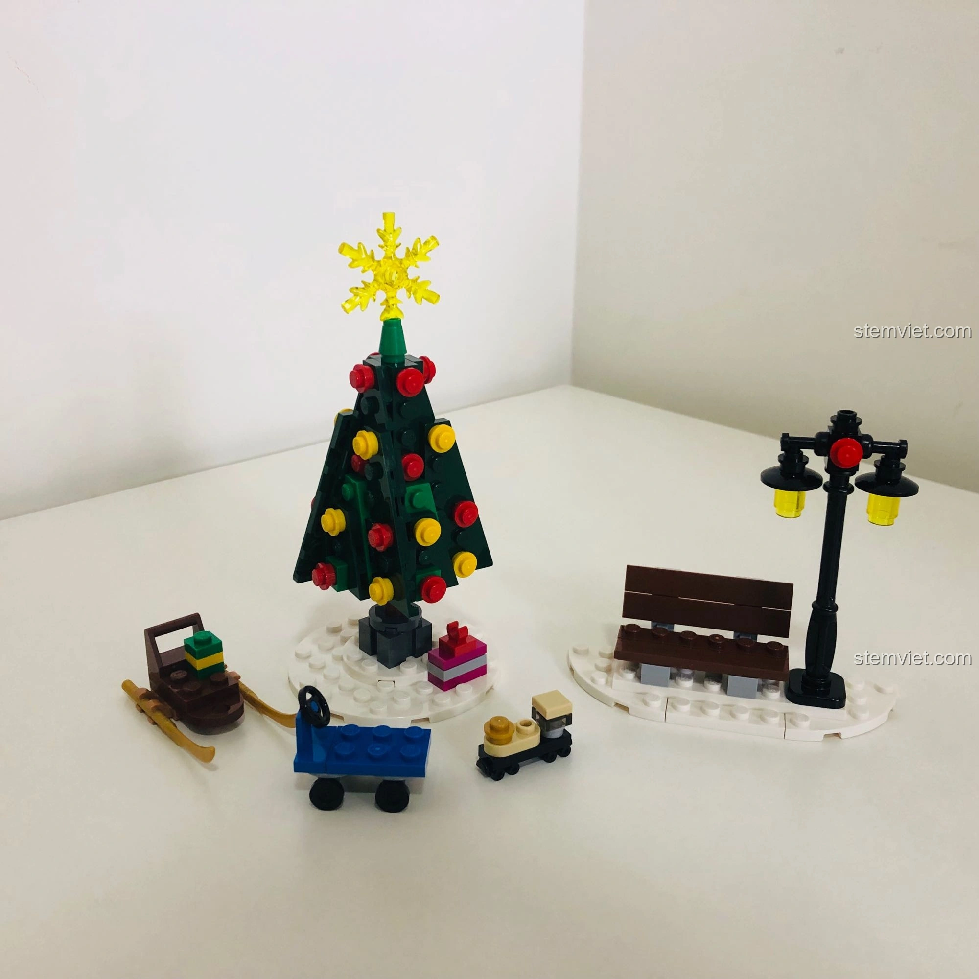 Các chi tiết phụ như cây thông Noel, ghế đá và đèn đường, tạo không khí mùa đông cho LEGO 10263.