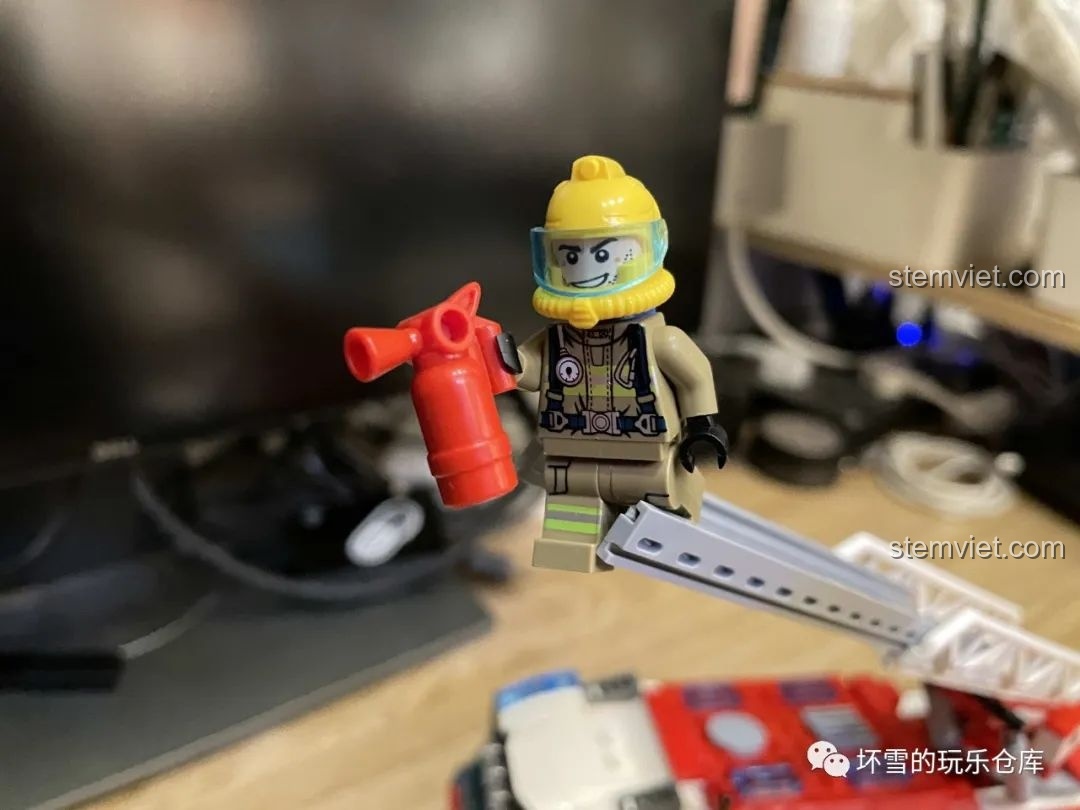 Minifigure lính cứu hỏa A Sâm đang cầm bình chữa cháy mini, chuẩn bị thực hiện nhiệm vụ trong bộ QMAN 2807.