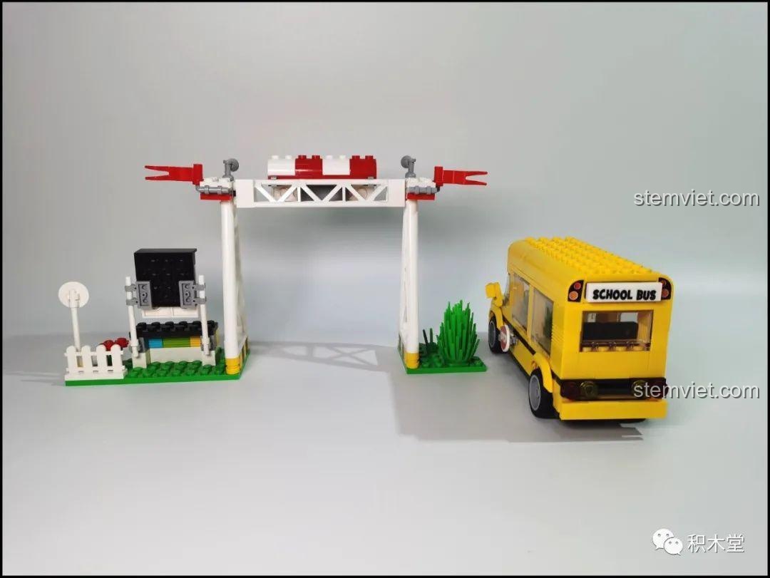 Cảnh quan bên cạnh của bộ lắp ráp LiNooS LN8006 Snoopy Hội Chợ Đường Phố và Xe Buýt Trường Học, với xe buýt và cổng hội chợ