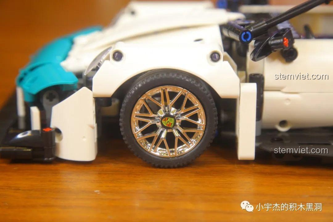 Cận cảnh bánh trước của xe KBOX 10214 với logo Porsche được dán ở trung tâm vành xe.