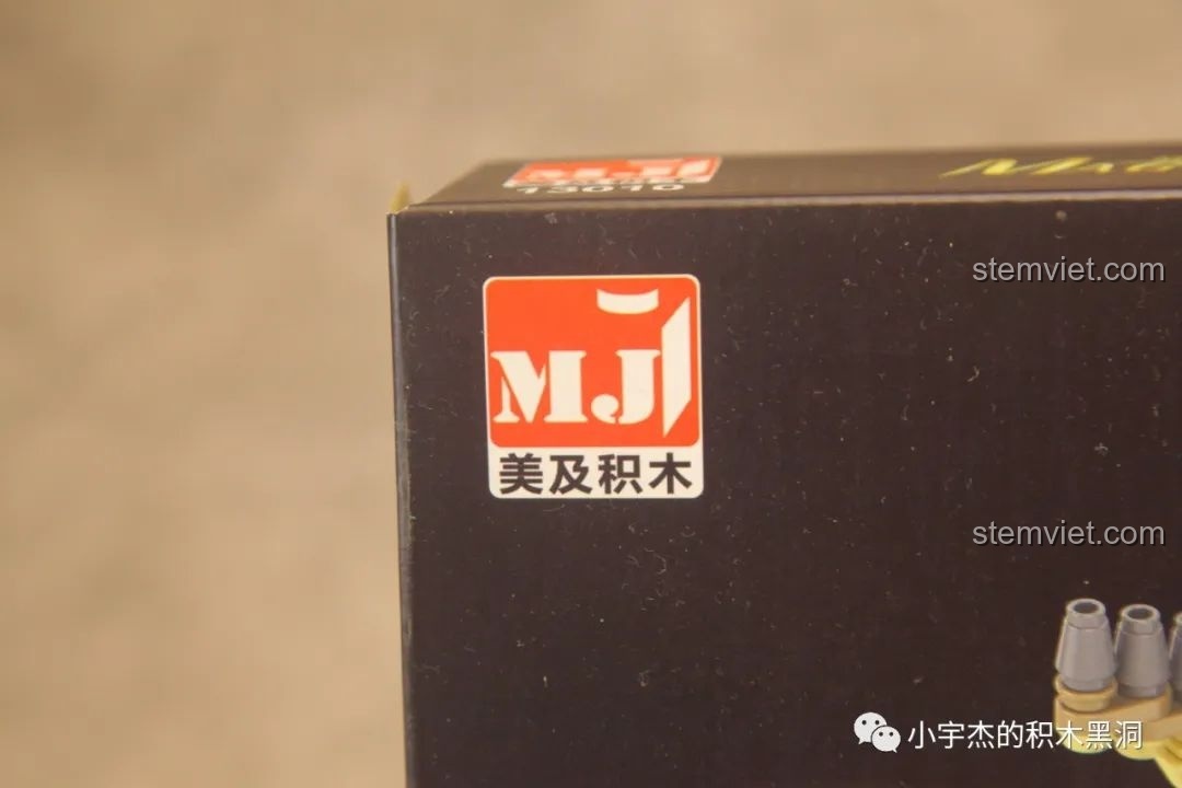 Cận cảnh logo thương hiệu Meiji (MJ) trên hộp đồ chơi lắp ghép Cuốn sách ma thuật Hogwarts 13010.