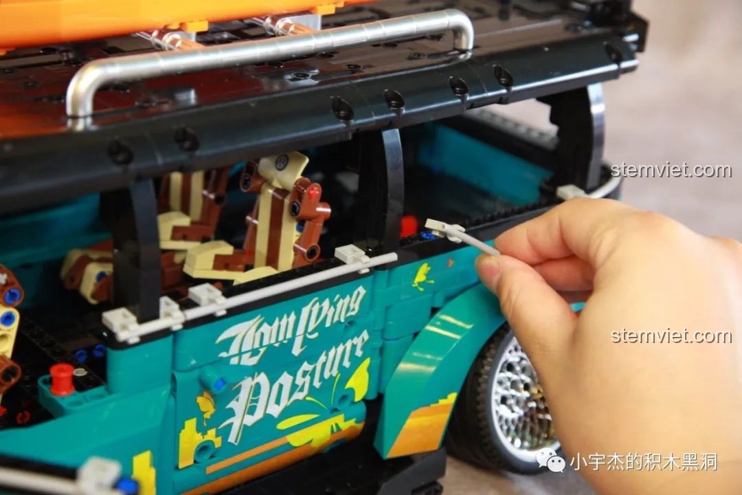 Một người đang điều chỉnh ống mềm trang trí trên thân xe K Box 10510, chi tiết này có thể gây cấn cửa.