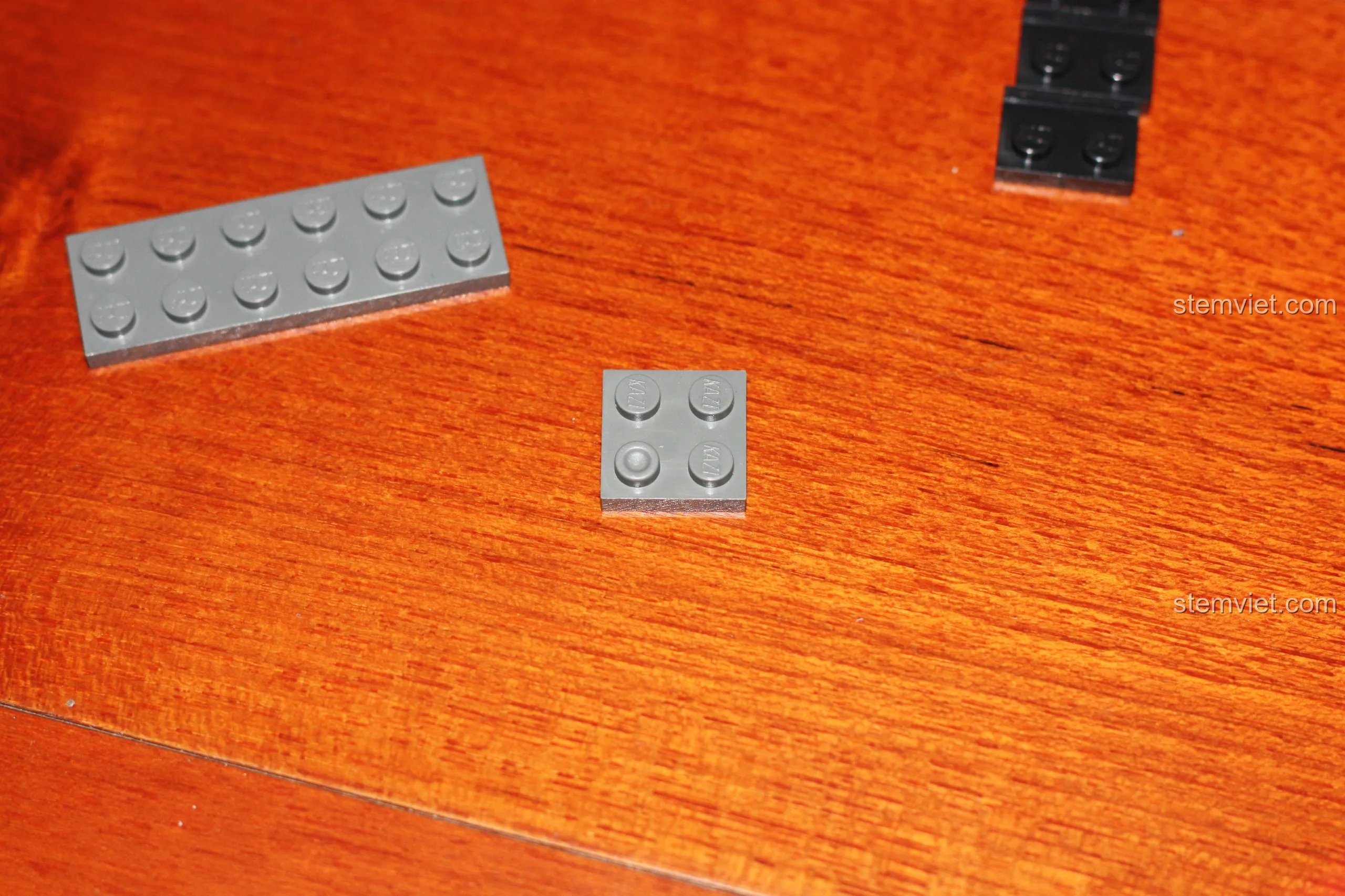 Một mảnh ghép 2x2 màu xám trong bộ lắp ráp Mô hình Xe Cứu Hỏa KY8054 bị lỗi thiếu một khớp nối tròn.