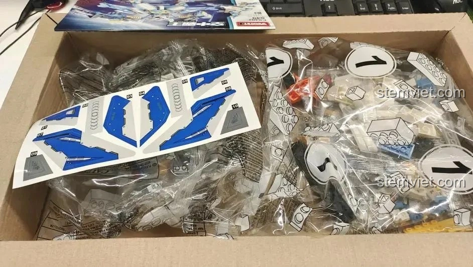 Các túi mảnh ghép và tấm sticker cánh máy bay bên trong hộp đồ chơi lắp ráp WOMA C0407.