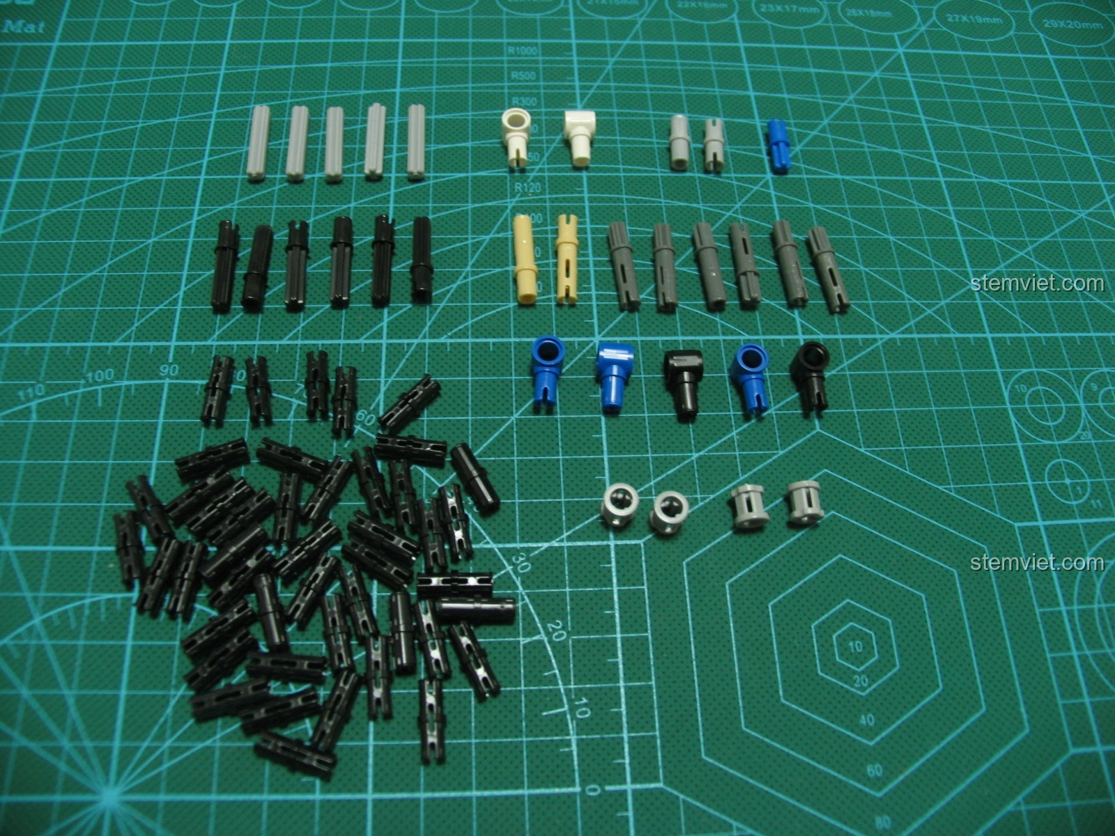 Các loại trục và chốt của bộ lắp ráp Súng trường tấn công AK-47 CaDA, được sắp xếp gọn gàng trên thảm cắt.