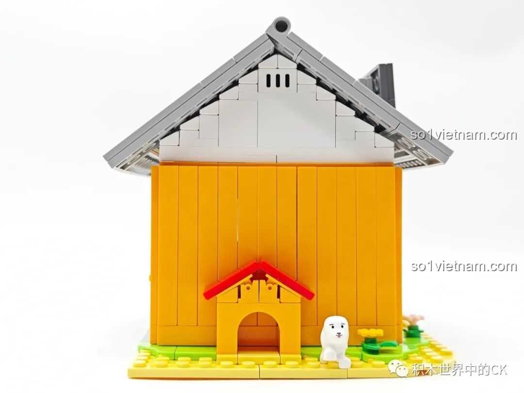 Mặt bên trái của mô hình Tiệm đồ ngọt Maruko, nổi bật với chuồng chó màu vàng và mái đỏ.