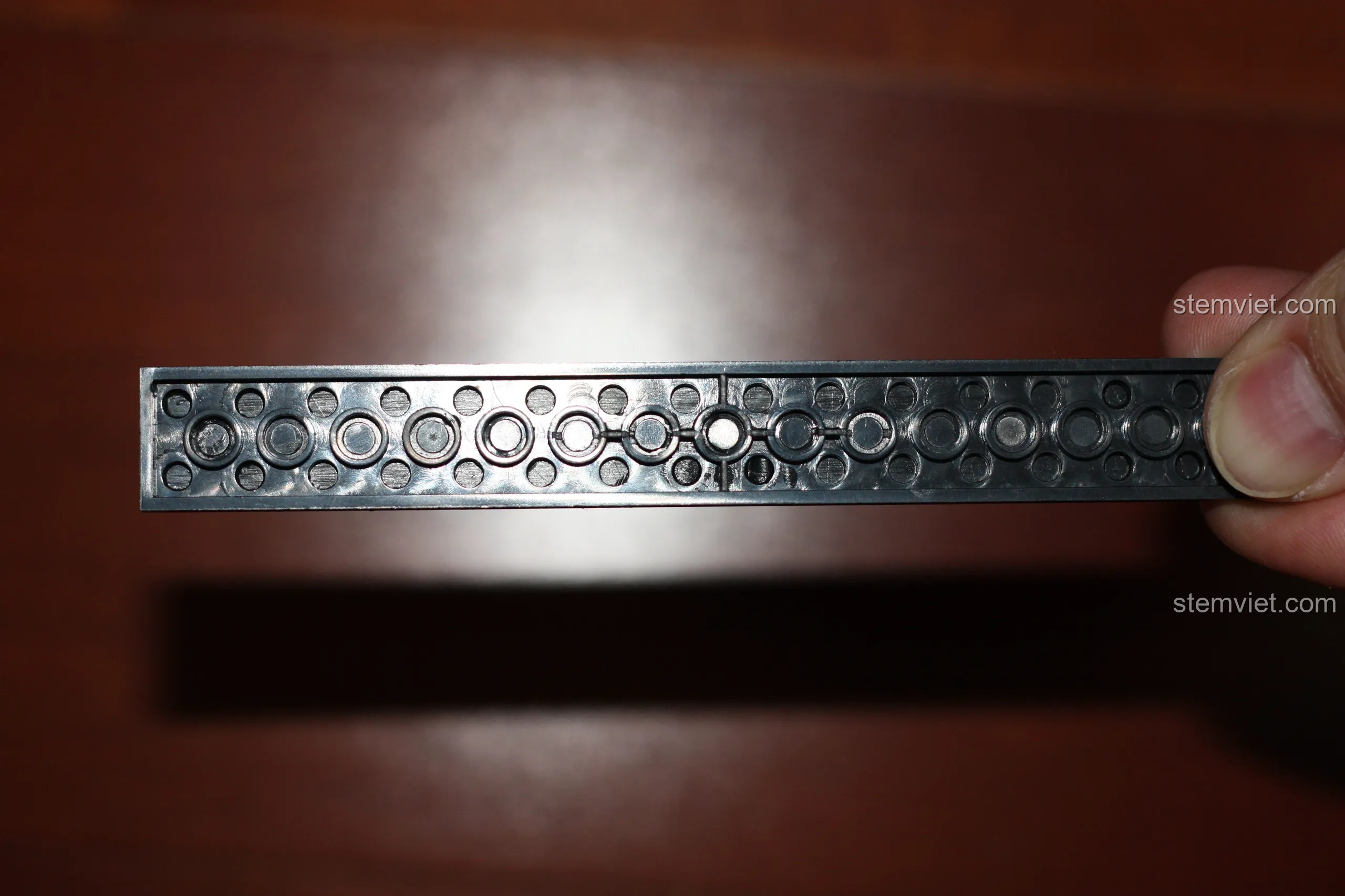 Mặt dưới của mảnh ghép trong bộ đồ chơi lắp ghép Xe Chữa Cháy KY8054, cho thấy cấu trúc khuôn đúc.