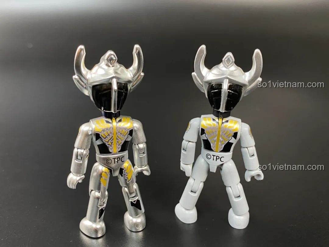 Mặt sau của hai phiên bản figure Ultraman Taiga, cho thấy sự khác biệt về lớp sơn.
