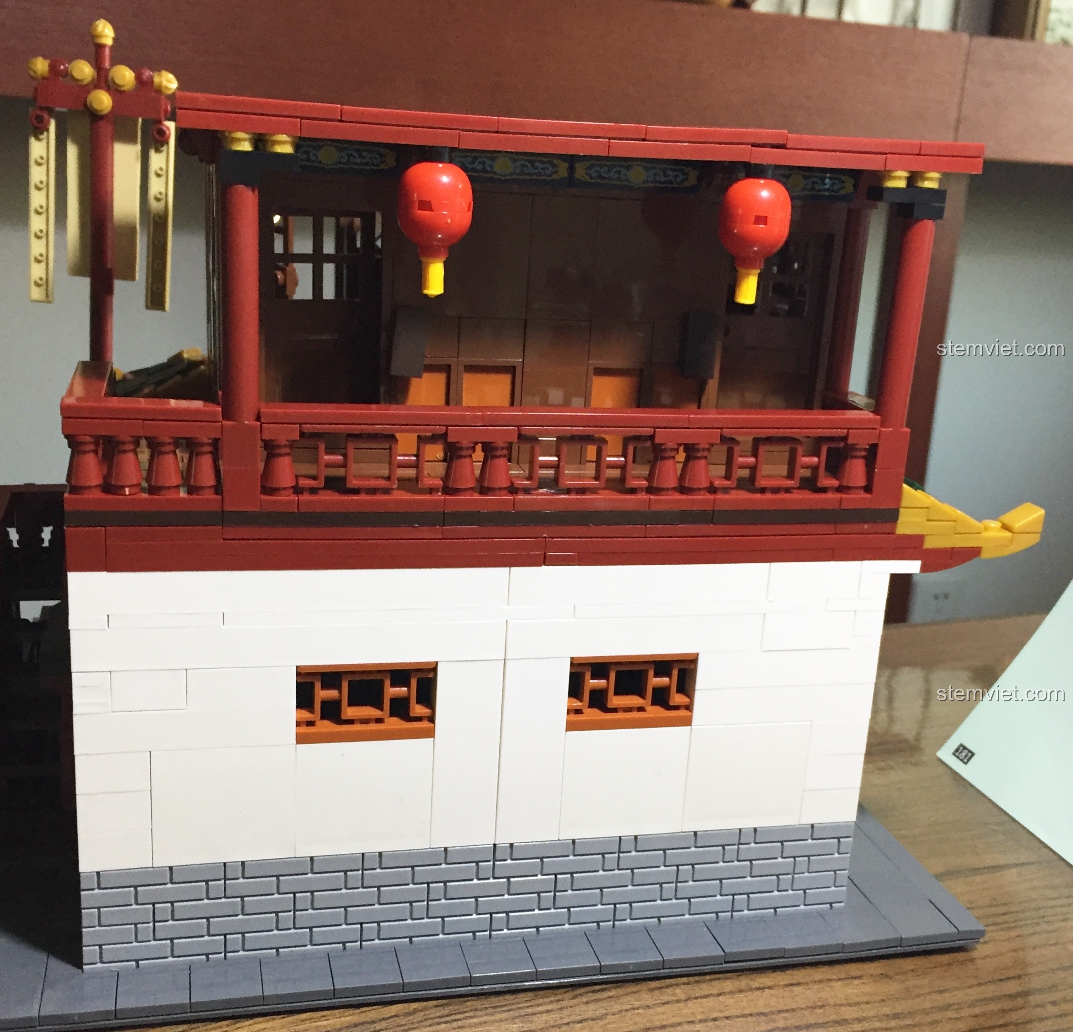 Mặt sau của Vạn Phúc Khách Sạn sau khi hoàn thành hai tầng, nổi bật với tường trắng và ban công đỏ.