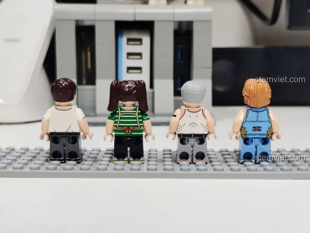 Mặt sau của bốn minifigure người lớn trong bộ Wekki 516954, thể hiện chi tiết in ấn trên lưng áo.