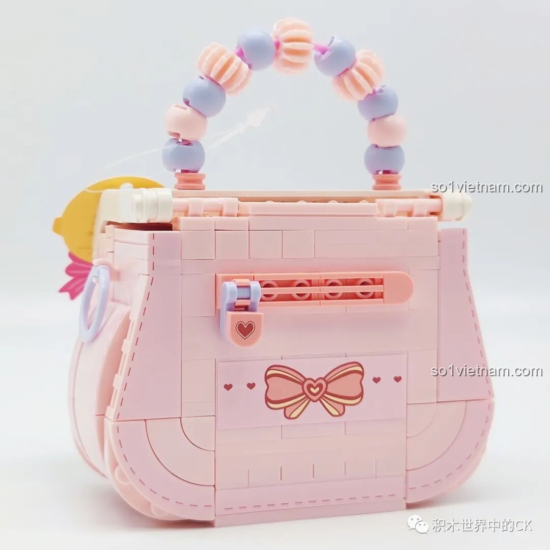 Mặt sau của túi xách Wekki 516909 với họa tiết nơ và khóa cài hình trái tim màu hồng.