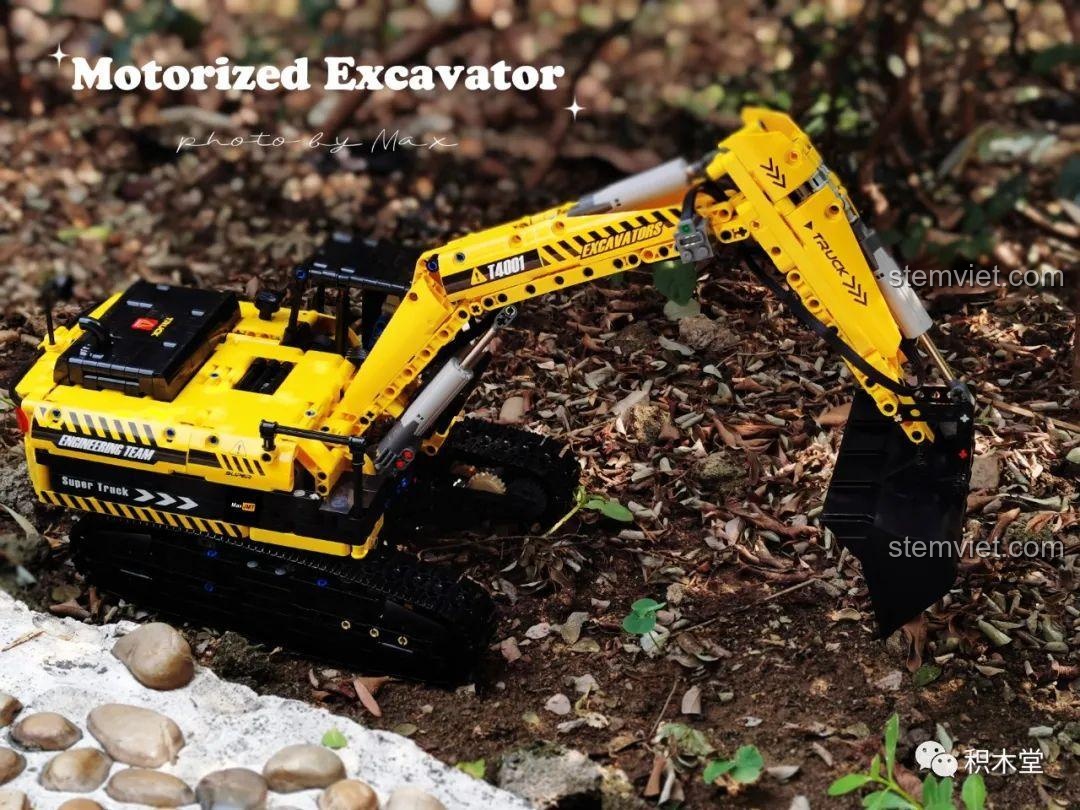 Mô hình máy xúc Taigaole T4001 trên nền cây xanh, tạo cảm giác tự nhiên và sống động.