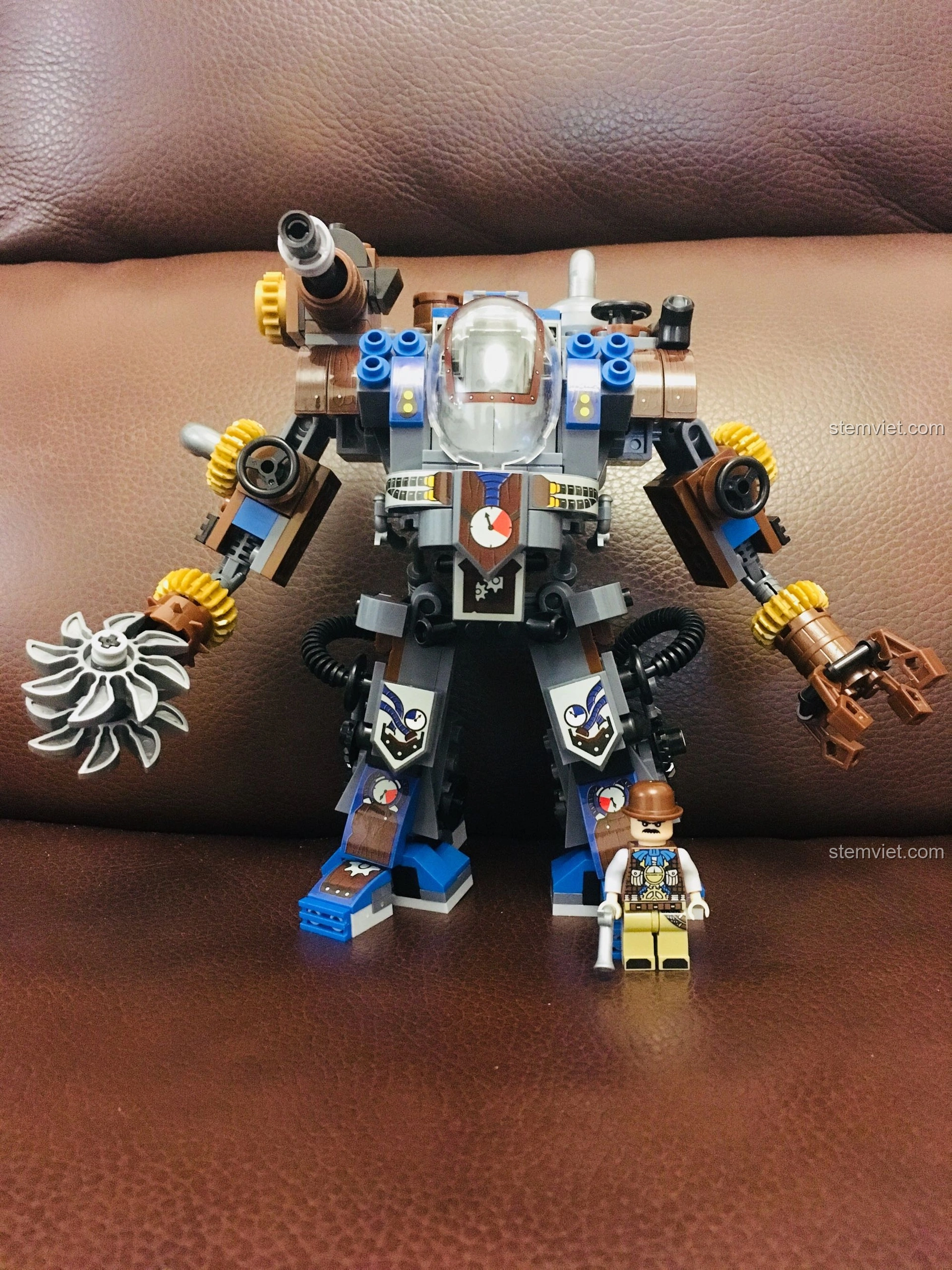 Mô hình mech Weile Steampunk đứng cạnh một minifigure, thể hiện tỉ lệ kích thước và sự tương tác giữa mô hình và nhân vật.