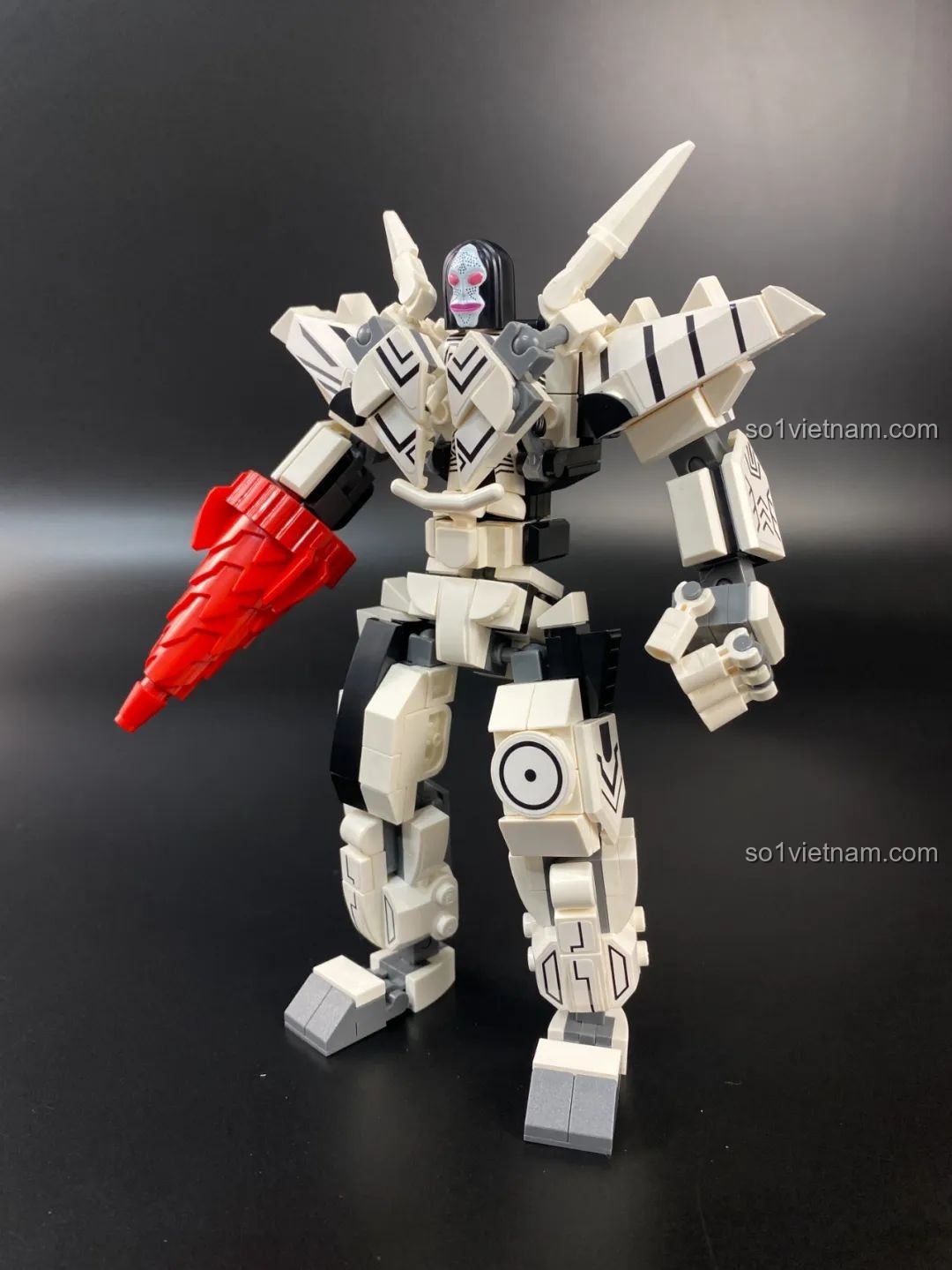 Mô hình Mecha Dada Qman 75050 tạo dáng chiến đấu, giơ cánh tay khoan về phía trước.