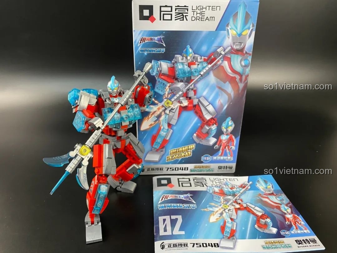 Mô hình Mecha Ginga Qman 75048 tạo dáng bên cạnh hộp và sách hướng dẫn, thể hiện sự hoành tráng.