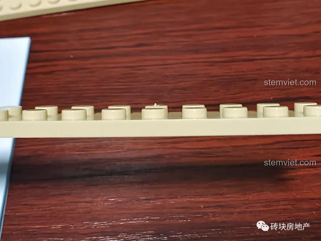 Kiểm tra chất lượng bề mặt của một mảnh ghép trong bộ đồ chơi mô hình Meiji 13010, cho thấy độ hoàn thiện tốt.