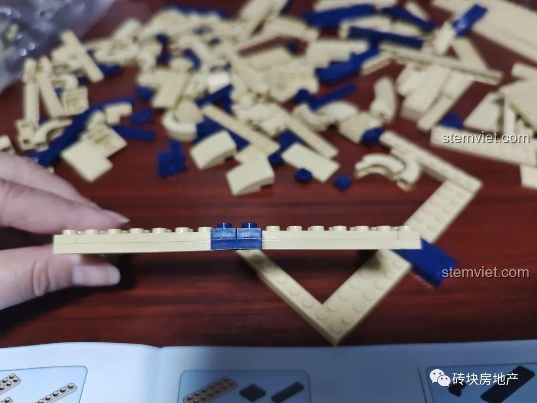 Phần gáy sách của mô hình Meiji 13010 đang được hình thành từ các mảnh ghép màu xanh dương.