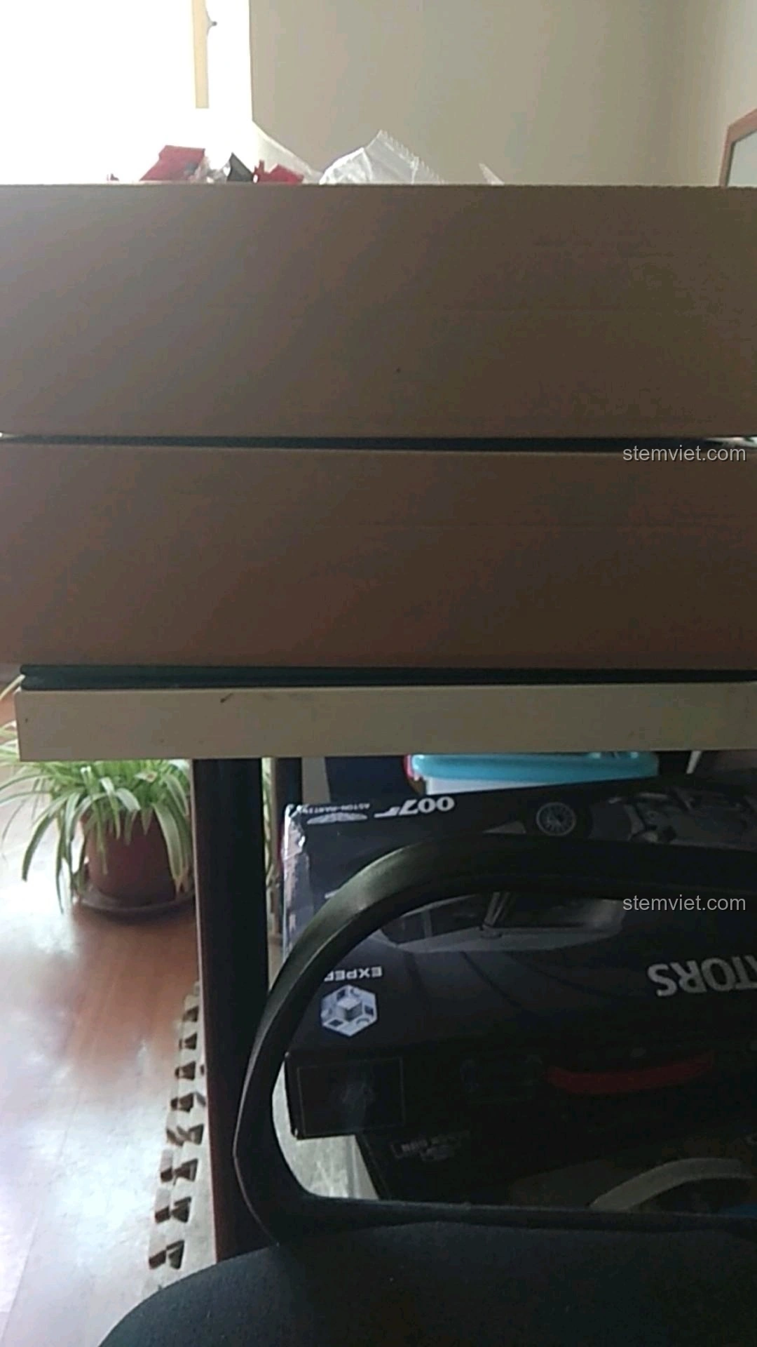 Sách hướng dẫn lắp ráp Đế Trưng Bày Voltron Bách Thú Vương SY 1130 được đặt dưới vật nặng để làm phẳng.