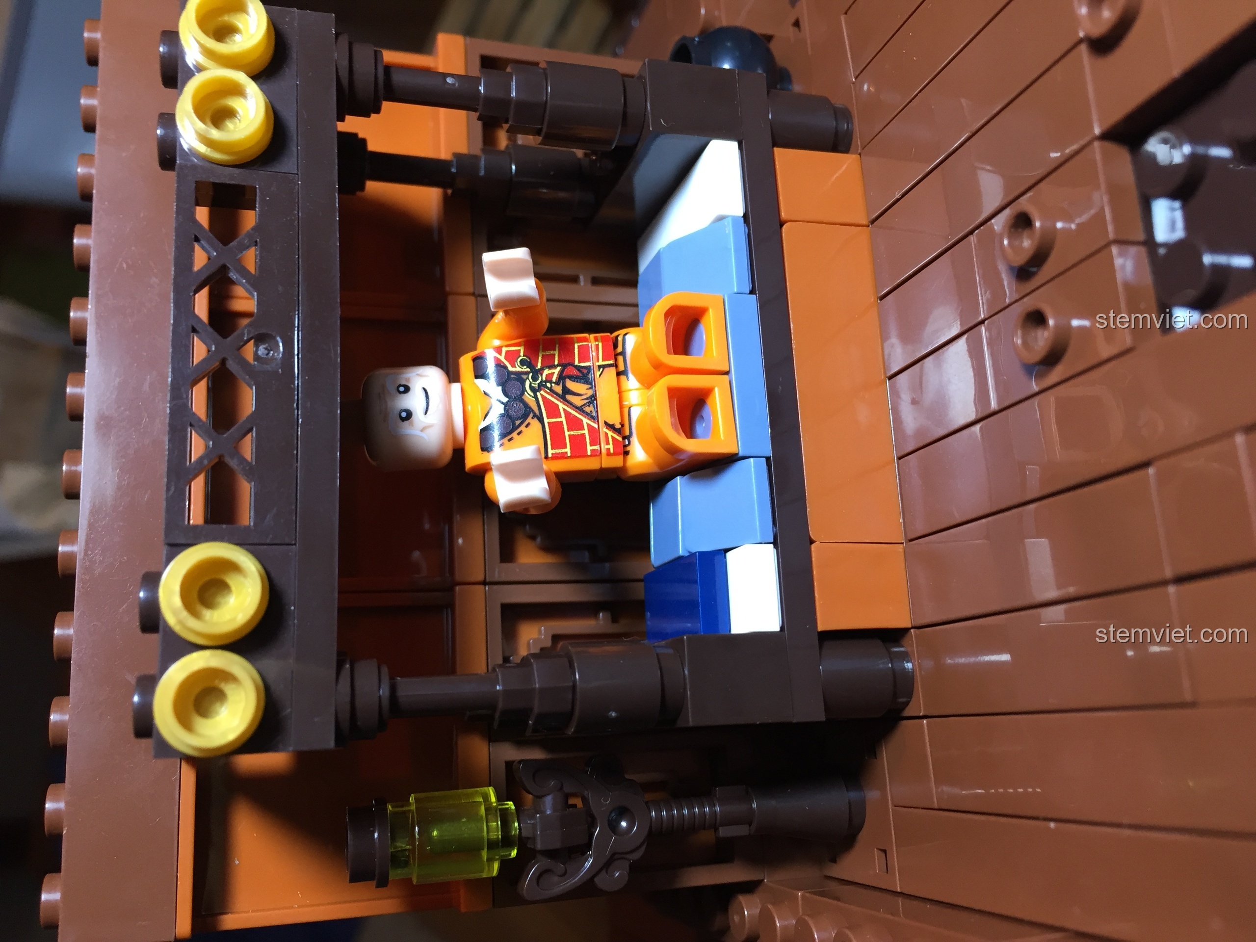 Minifigure cao tăng nằm trên giường trong phòng ngủ tầng hai của Vạn Phúc Khách Sạn.