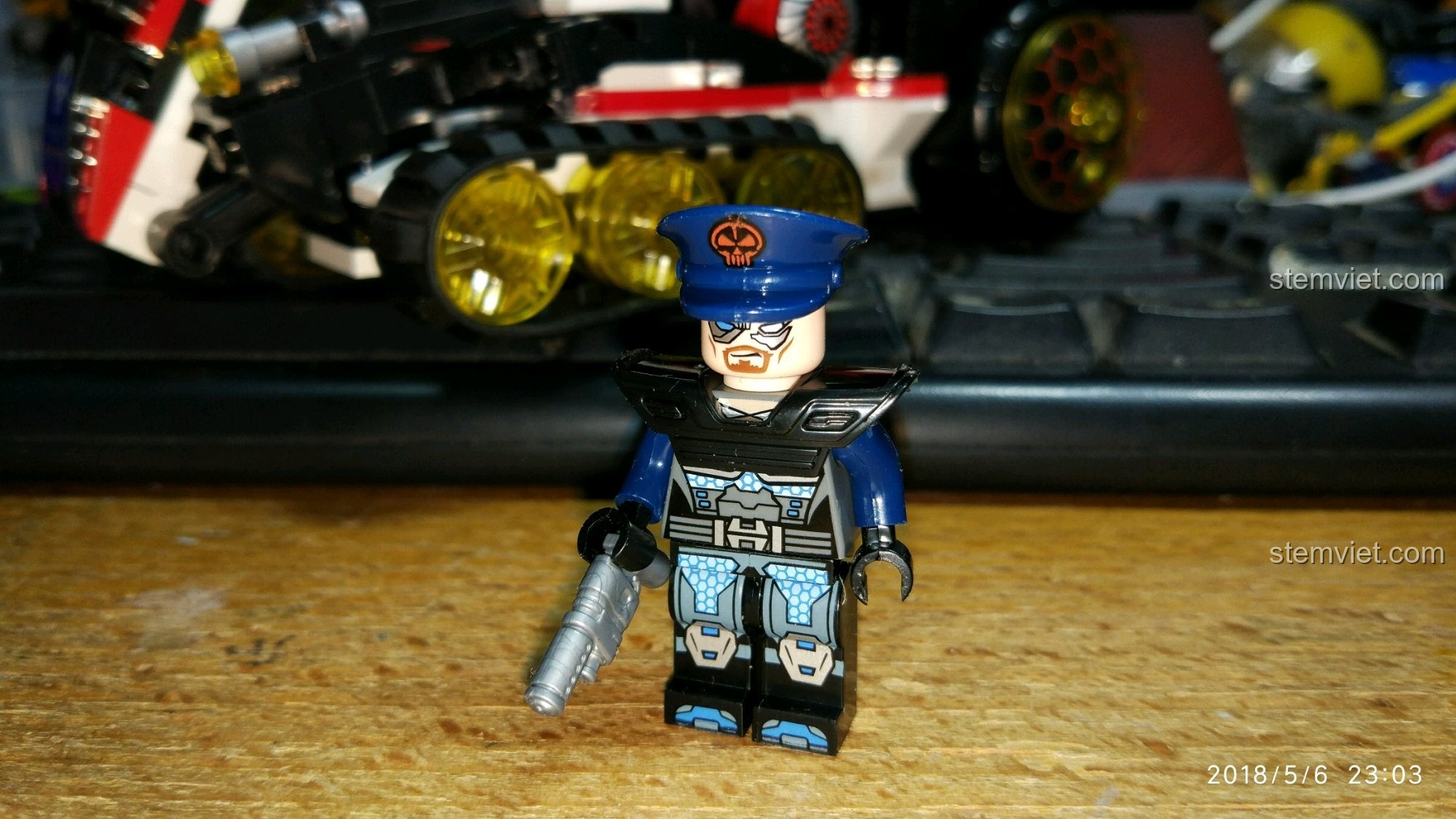 Minifigure chỉ huy phe phản diện trong bộ QMAN 2715, đội mũ lưỡi trai và mặc giáp vai.