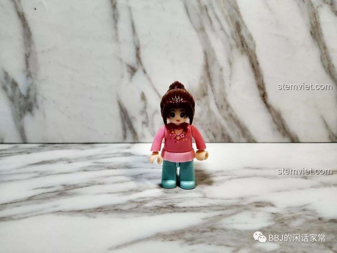 Cận cảnh minifigure cô bé khách hàng trong bộ Sluban B0705H với mái tóc nâu và trang phục màu hồng.