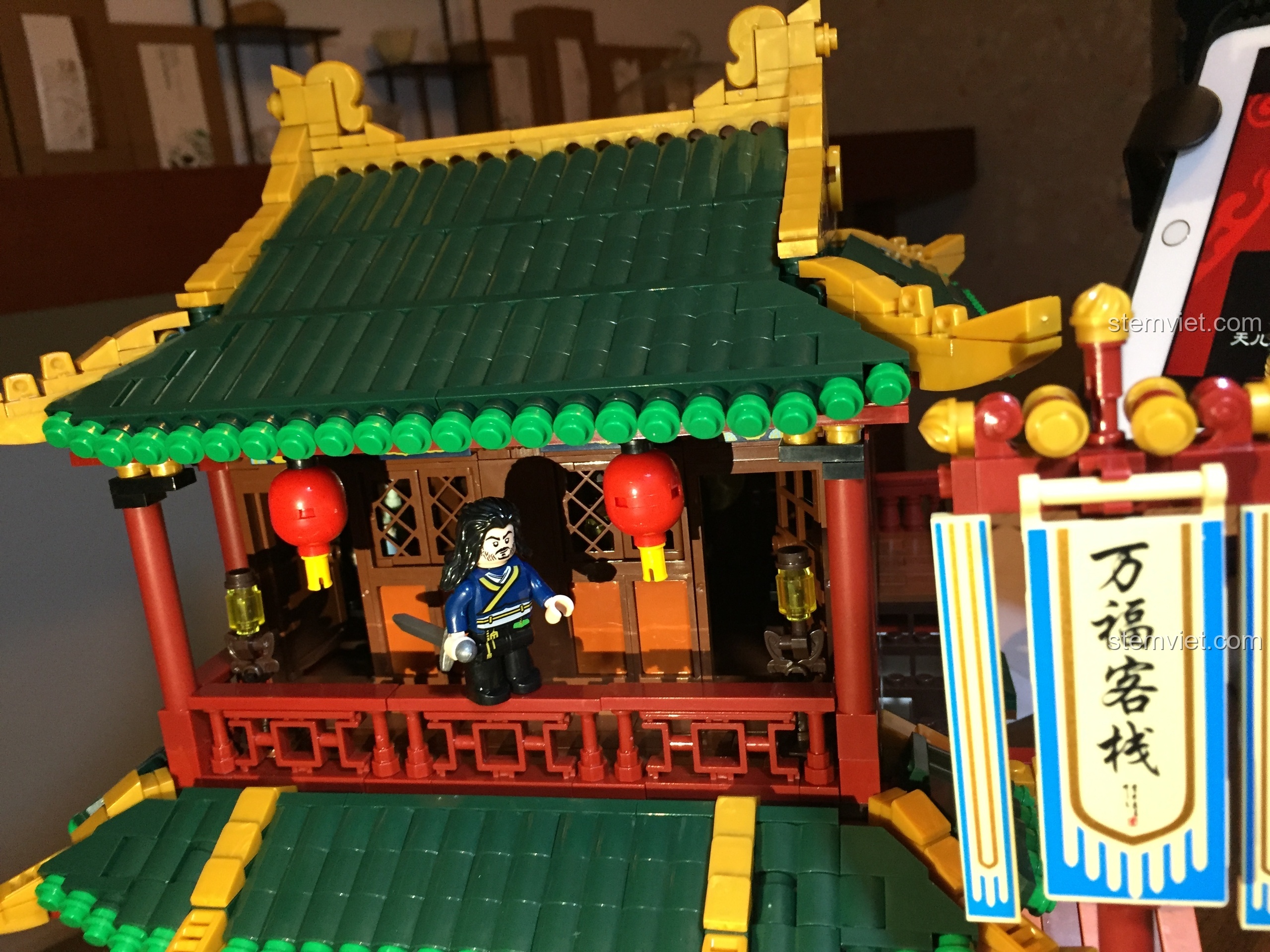 Minifigure đại hiệp đứng trên ban công tầng hai của Vạn Phúc Khách Sạn, tạo nên một khung cảnh ấn tượng.