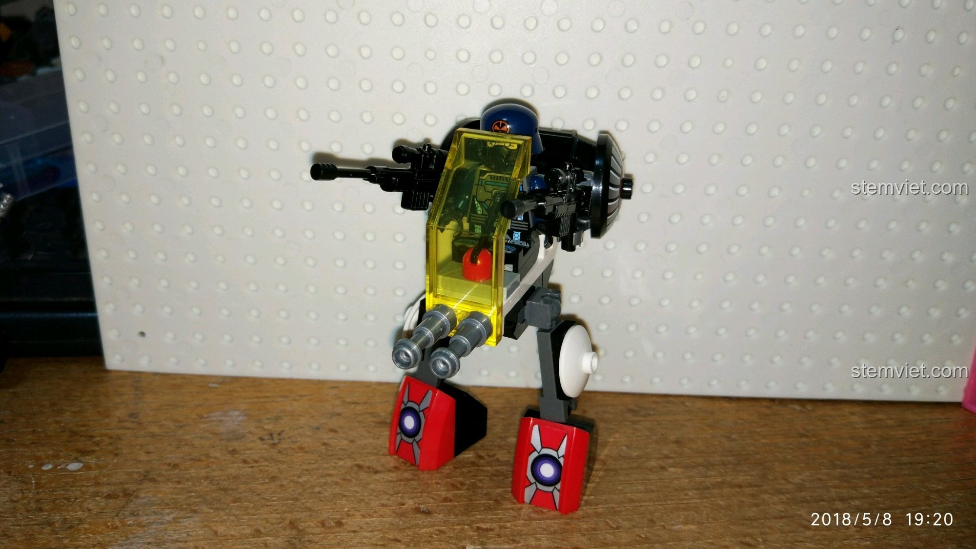 Minifigure lính phản diện đang ngồi trong buồng lái của robot mini QMAN 2713.