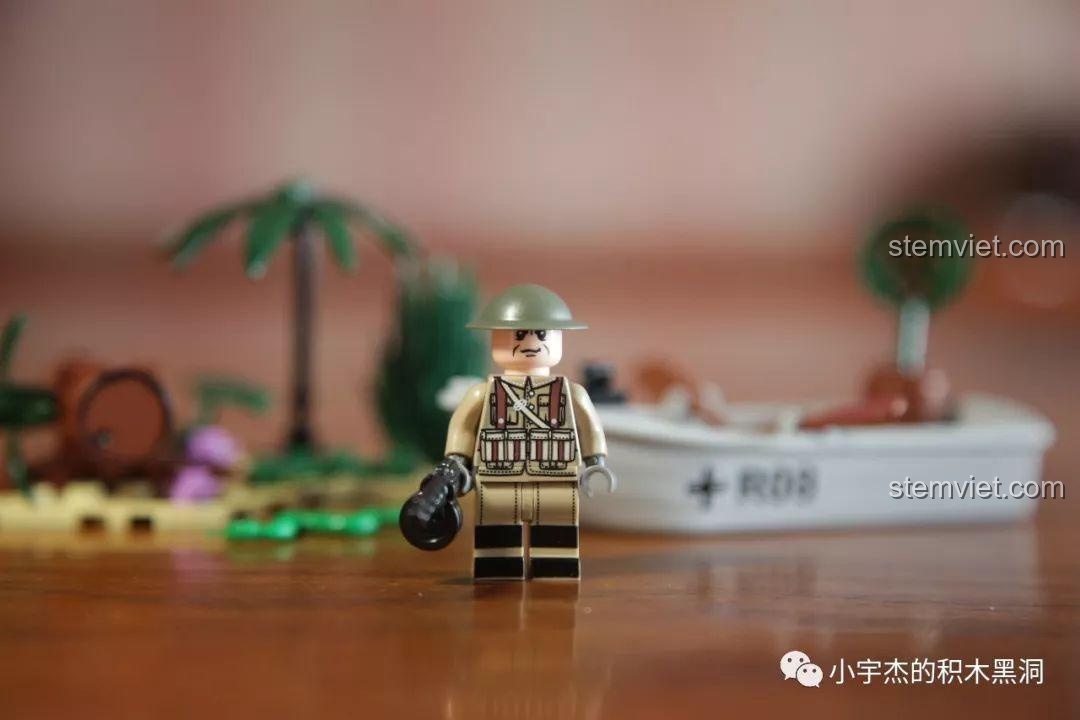 Cận cảnh minifigure lính Anh trong bộ SEMBO 101108, cầm súng và đứng trước mô hình thuyền tuần tra.