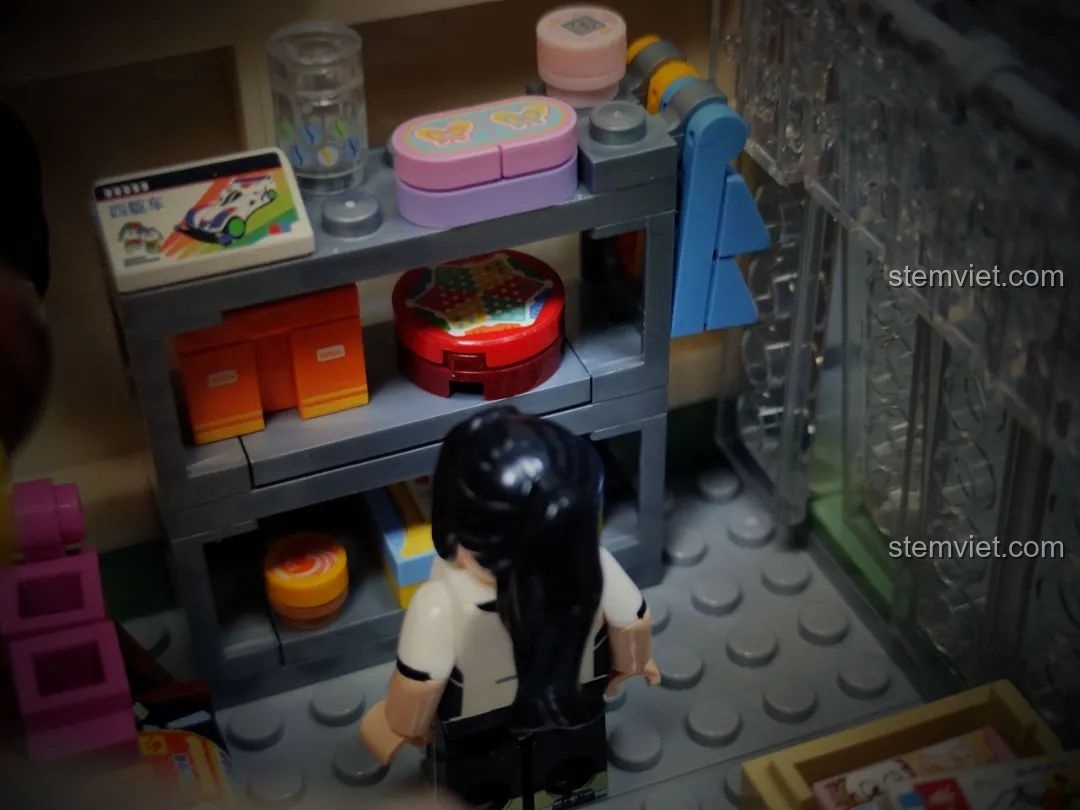 Một minifigure nữ đang xem các món đồ lưu niệm trong hiệu sách của mô hình Wekki 516954.