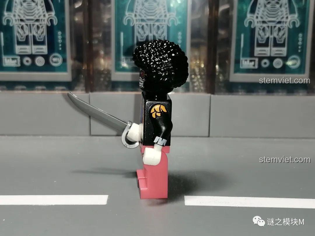 Góc nhìn bên cạnh của minifigure Brook, thể hiện chi tiết in trên cánh tay và mái tóc xù.