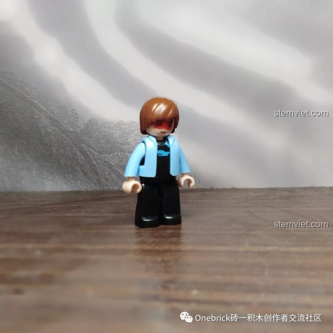 Minifigure đi kèm bộ xếp hình Sluban ModelBricks Xe Vàng M38-B0706C, đứng một mình trên nền gỗ.