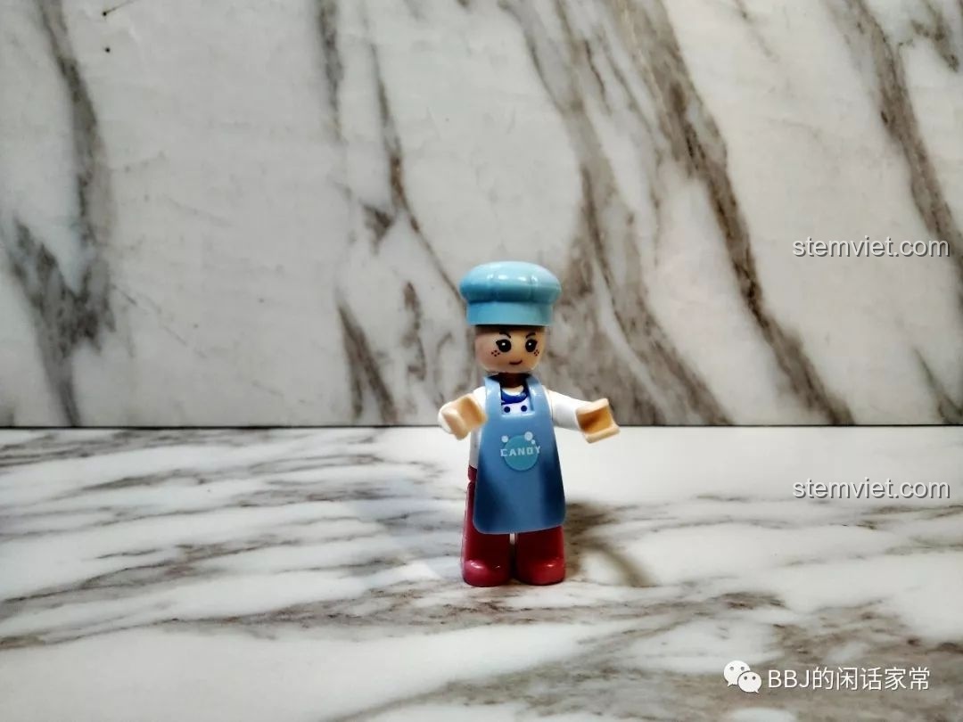 Cận cảnh minifigure anh thợ làm bánh trong bộ Sluban B0705H, mặc tạp dề xanh và đội mũ trắng.