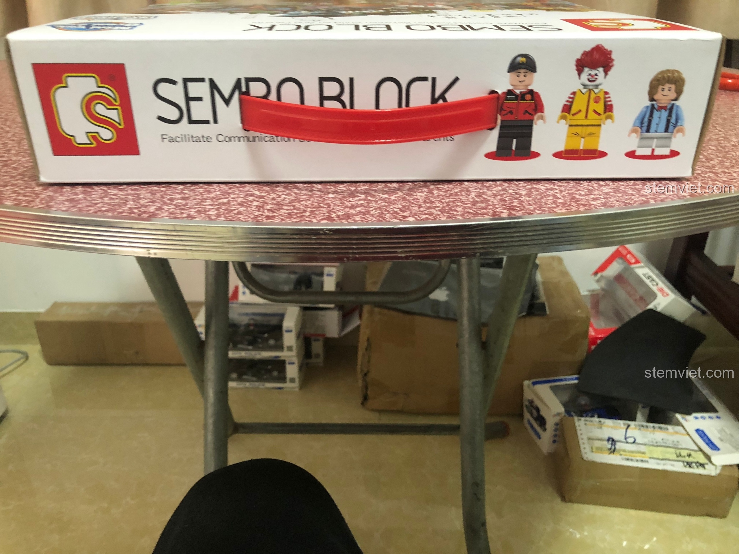 Cạnh trên của hộp Sembo 601021 có quai xách và hình ảnh 3 minifigures, bao gồm một chú hề.