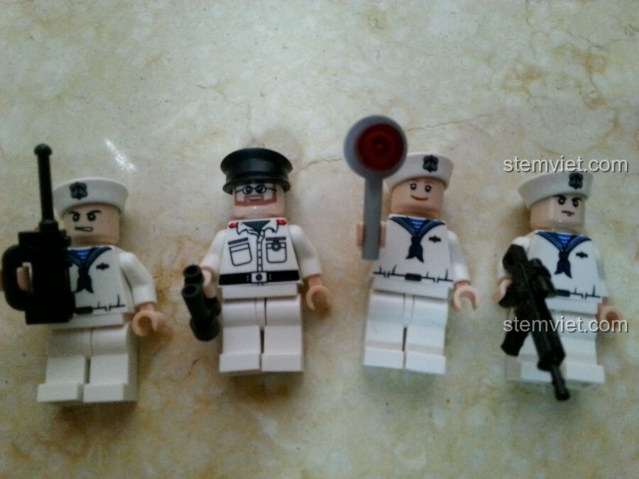 Bốn minifigures lính hải quân đi kèm bộ lắp ráp GUDI 8026 Tàu Hộ Vệ Tên Lửa, với trang phục và phụ kiện chi tiết.