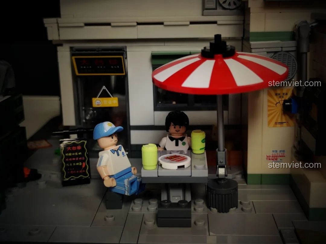 Hai minifigure học sinh đang ngồi tại bàn cà phê vỉa hè trong mô hình Wekki 516954.