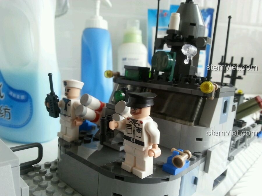 Các minifigures lính hải quân được đặt trên boong tàu của mô hình GUDI 8026 Tàu Hộ Vệ Tên Lửa, tạo cảnh quan sống động.