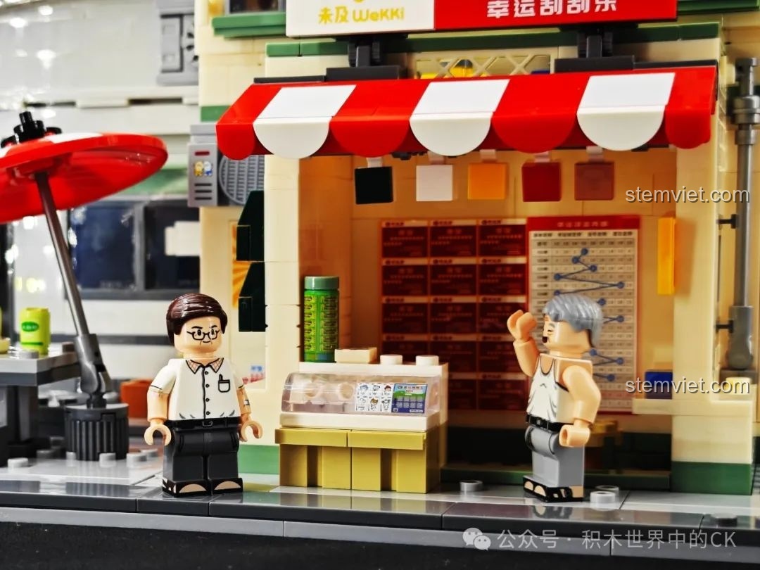 Cảnh hai minifigures Ông chủ Cẩm và Vương Dục Tài đang tương tác trước tiệm xổ số trong bộ Wekki 516954.