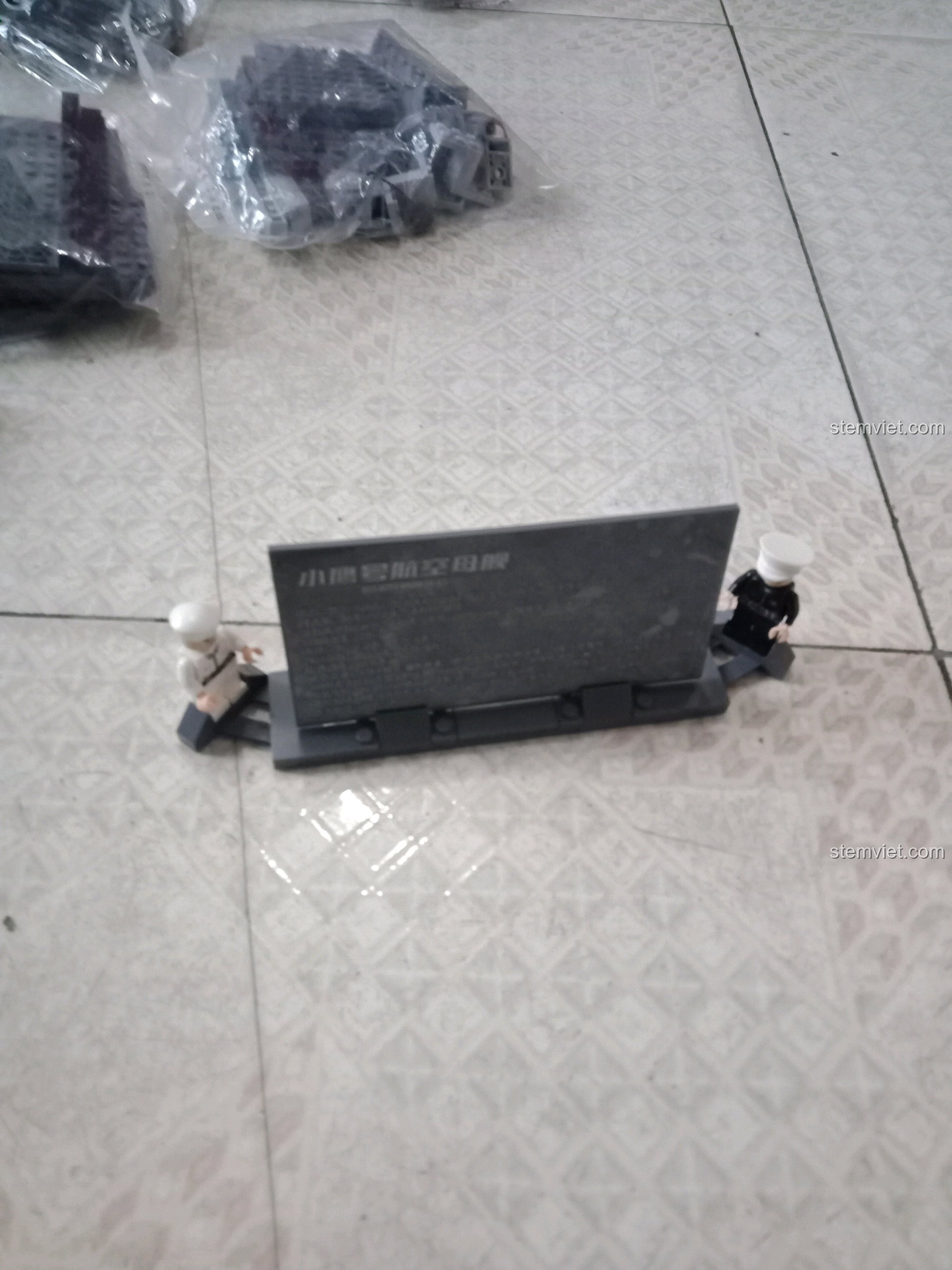 Hai minifigure sĩ quan và tấm biển trưng bày của bộ xếp hình Tàu chiến USS Kitty Hawk KAZI KY10002.