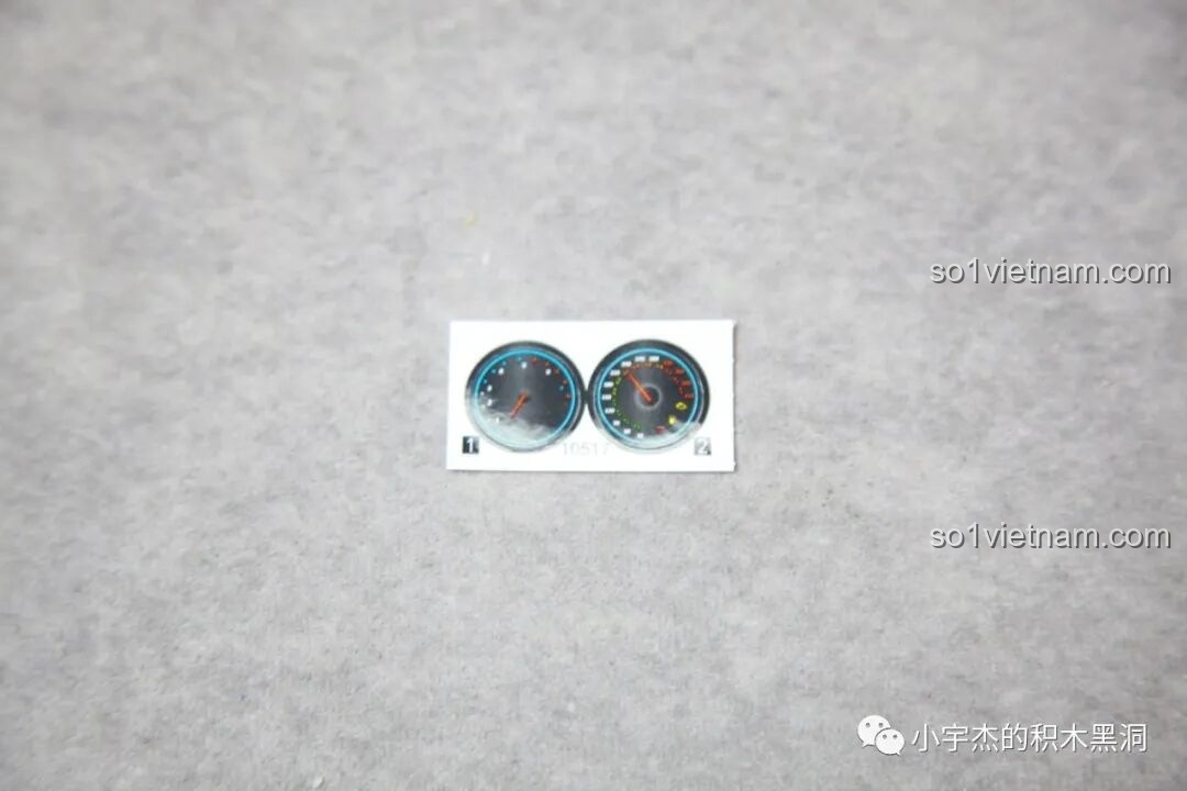 Cận cảnh tấm sticker nhỏ với họa tiết bảng điều khiển, dùng để trang trí nội thất của mô hình Batmobile Tumbler K-Box 10517.