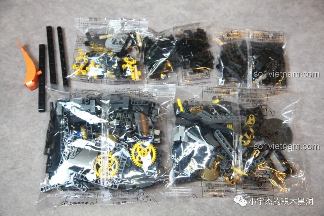 Các mảnh ghép trong túi số 1 của bộ K-Box 10517 Xe Batman Rambom, bao gồm nhiều chi tiết màu đen và vàng, dùng để xây dựng phần khung cơ bản.