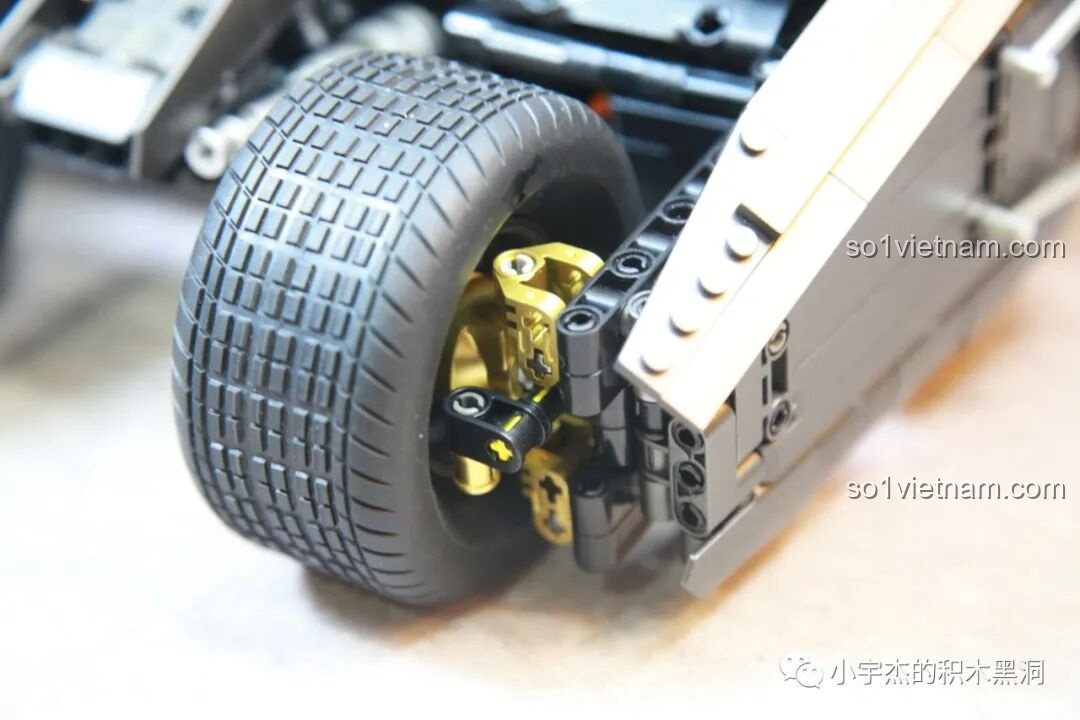 Chi tiết ống xả và hệ thống treo phía sau của mô hình Batmobile Tumbler K-Box 10517, với lò xo màu xanh và các mảnh vàng.