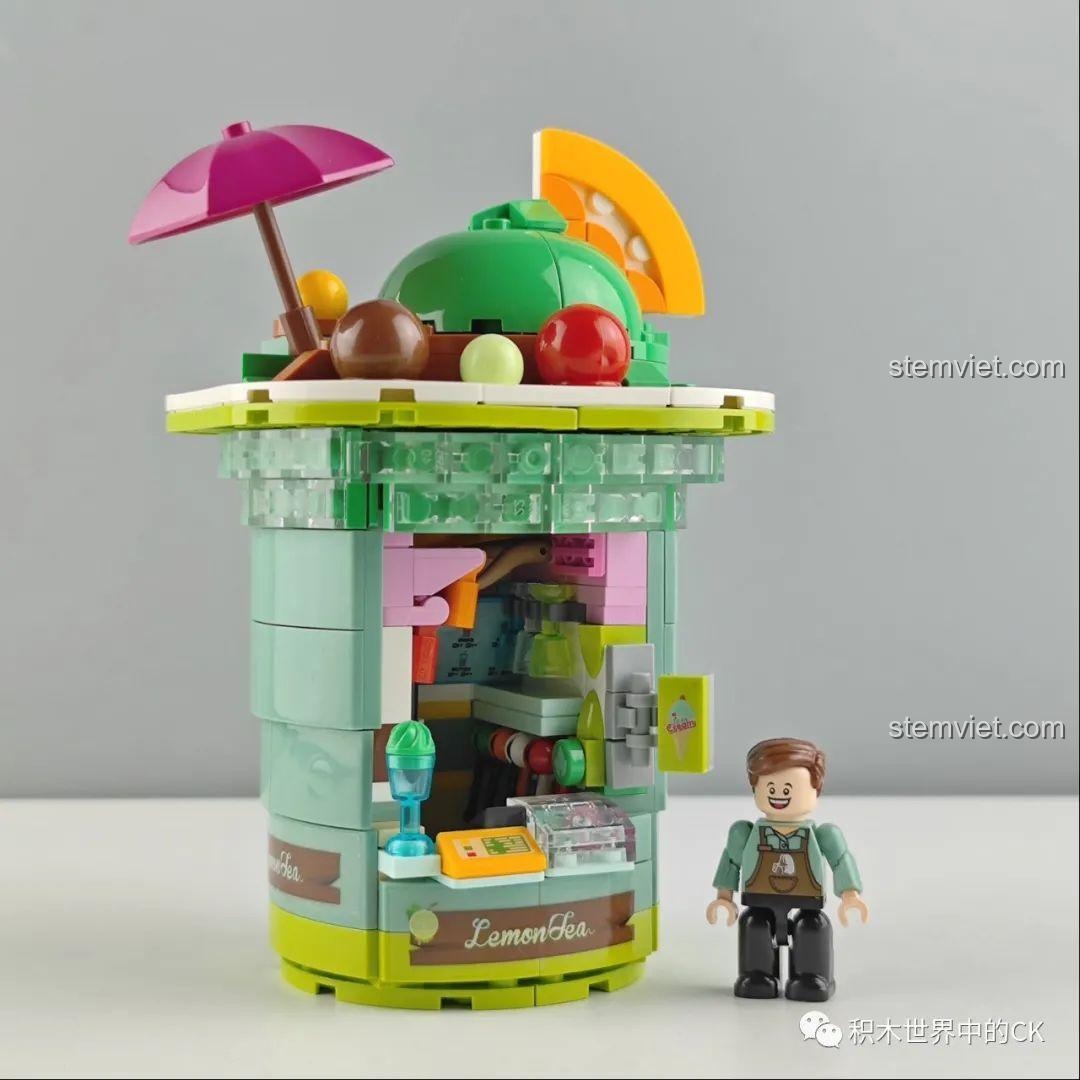 Mô hình Cửa hàng Matcha Zhe Gao CW6005 đã hoàn thành, màu xanh lá chủ đạo, có ô và trái cây trang trí.