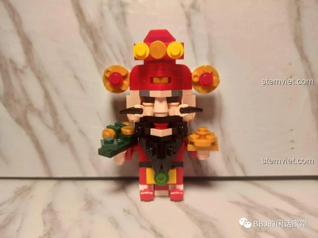 Mô hình Lộc Tinh ZHEGAO QL0953-2 với trang phục xanh lá, cầm cuộn thư và em bé, biểu tượng của công danh và tài lộc.