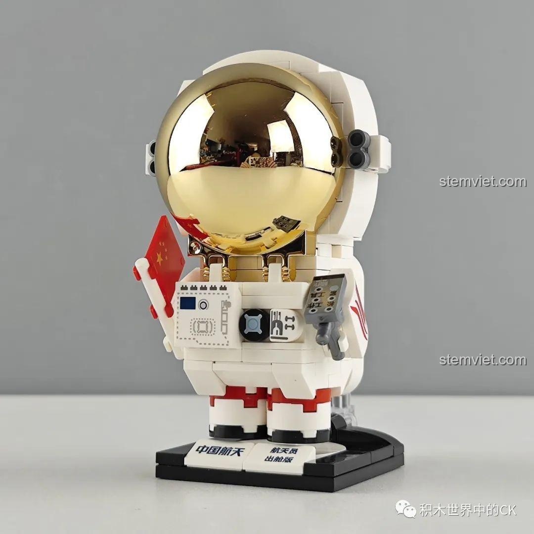 Mô hình phi hành gia Keeppley K10209 hoàn chỉnh với mũ bảo hiểm mạ vàng sáng bóng và lá cờ trên tay.