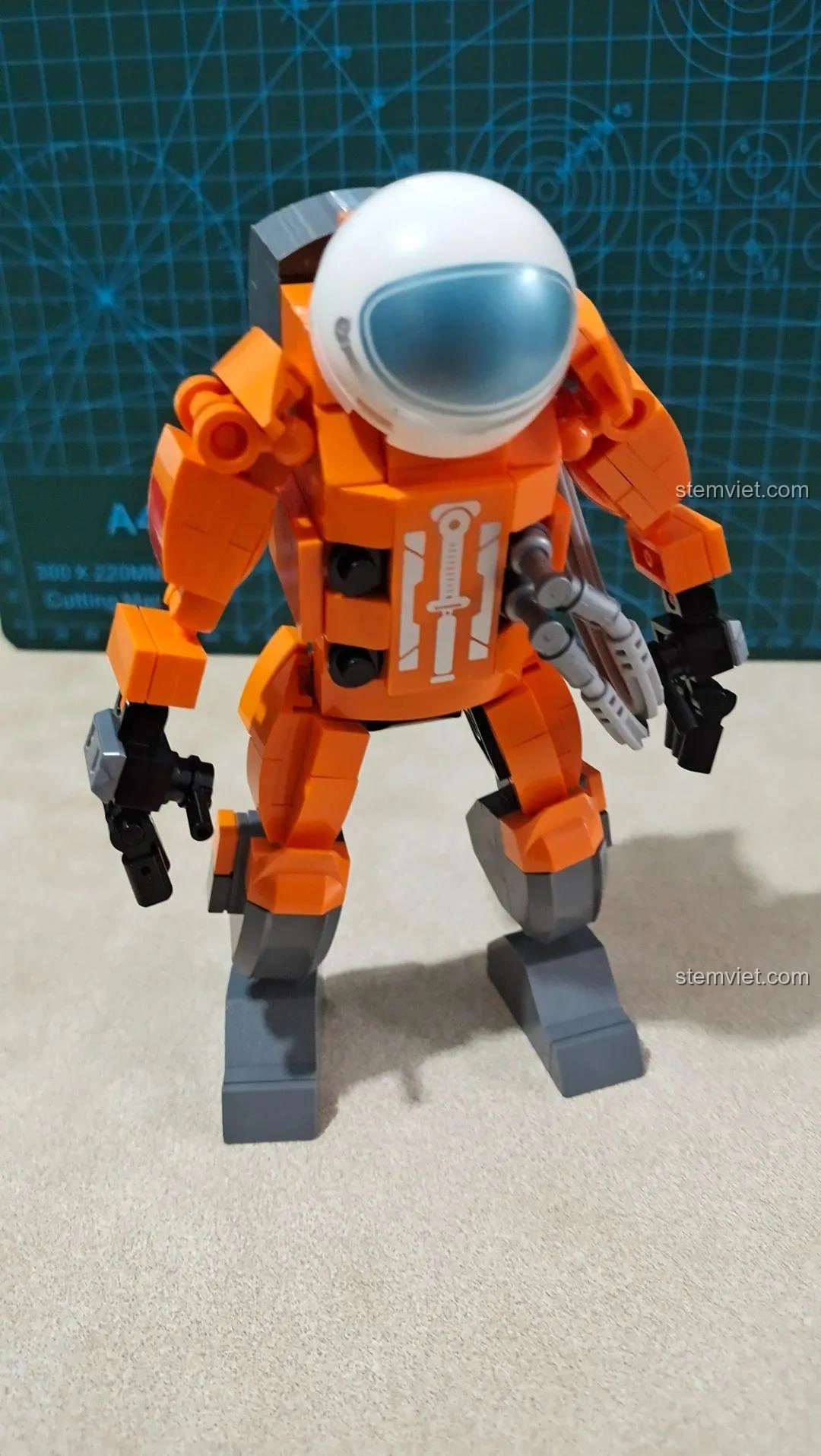 Mô hình Phi hành gia WISE BLOCK HA390206 đã hoàn thành, nhìn từ mặt trước, với bộ giáp cam nổi bật và mũ bảo hiểm trắng.