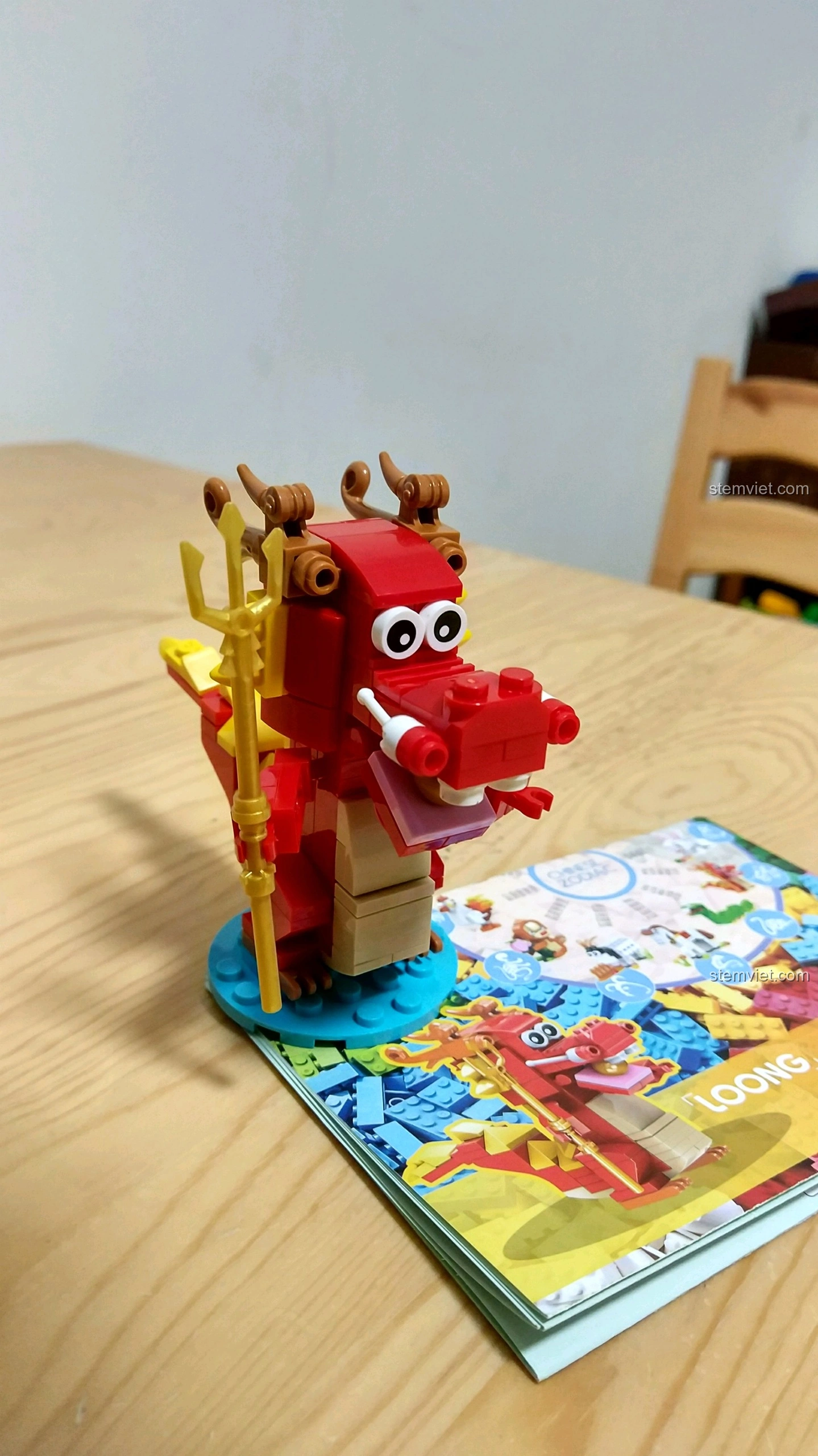 Mô hình Rồng Thìn màu đỏ rực rỡ từ bộ lắp ráp 12 Con Giáp XINGBAO XB-18001, đứng vững trên đế xanh, cầm đinh ba vàng.