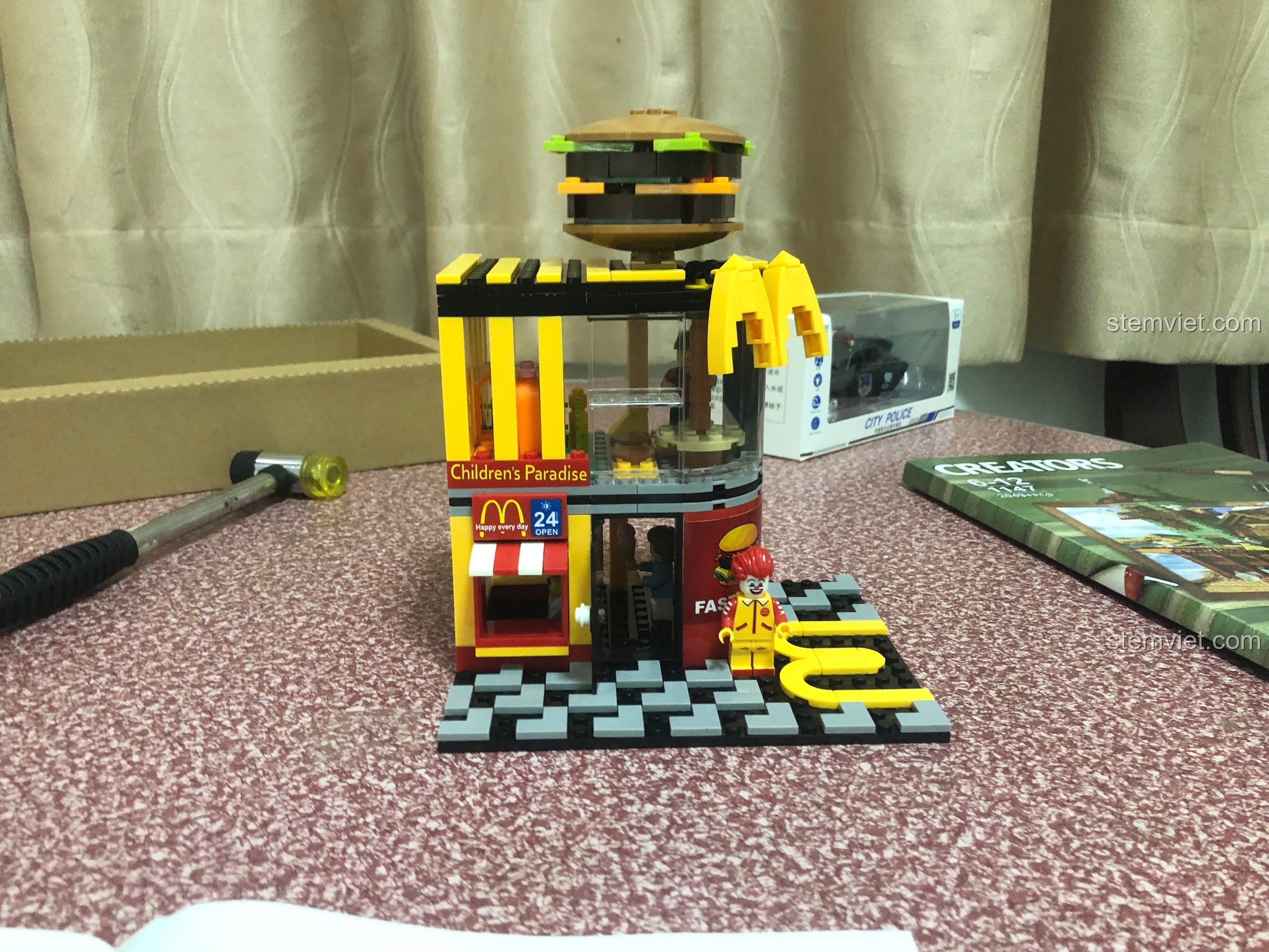 Mô hình cửa hàng thức ăn nhanh Sembo 601021 đã hoàn thành với chú hề minifigure đứng phía trước.